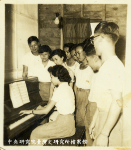 1958年政工幹校專六期音樂科同學與高慈美（立於彈琴者右手邊）合照
